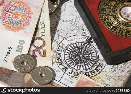 Chinese coins and a feng shui compass on a map