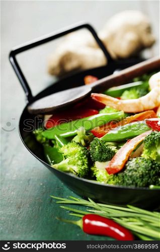 Chinese cuisine. Colorful stir fry in a wok. Shrimps with vegetables