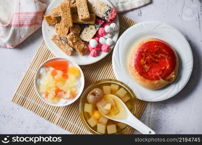 Chinese desserts chinese pastry bean cake, Snack mix nuts candies sweets sugar nuts sesame seeds coated beans puffed rice, milk pudding fruit salad longan juice bowl in chinese new year festival food