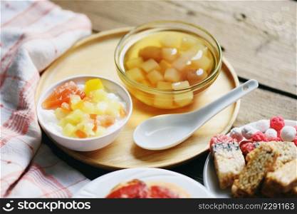 Chinese desserts, milk pudding fruit salad and Mix ginkgo nuts cassava syrup coconut jelly in longan juice on glass bowl, Thai and Chinese longan date soup Asian dessert sweets 