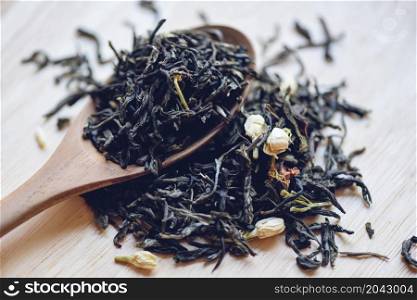 Chinese dry tea on wooden spoon, jasmine tea dried for brew tea, leaf black tea