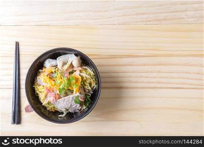 Chinese egg noodles and pork on wood table