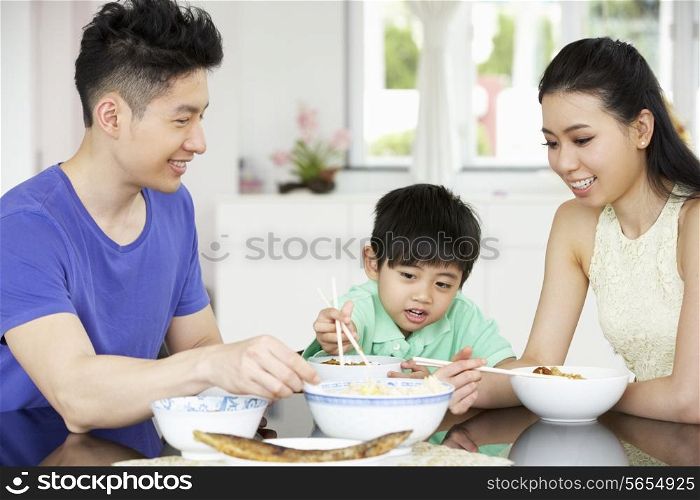 Chinese Family Sitting At Home Eating A Meal