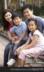 Chinese Family Walking Sitting On Bench In Park Together