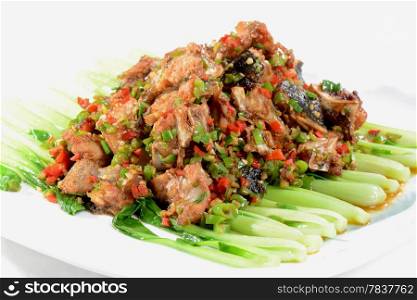 Chinese Food: Fried fish head pieces with green vegetables in a white plate
