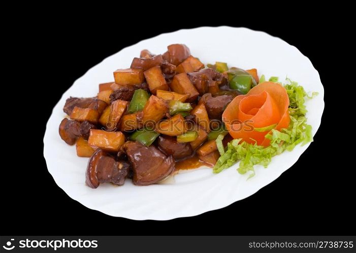 Chinese food. Fried pork with potatoes and paprika under sour sweet sauce, decorated with tomato flower.
