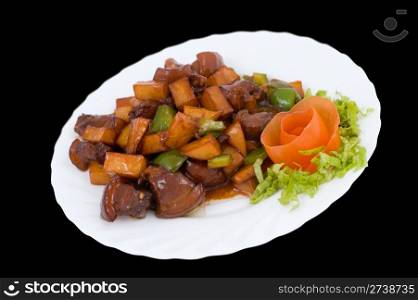 Chinese food. Fried pork with potatoes and paprika under sour sweet sauce, decorated with tomato flower.