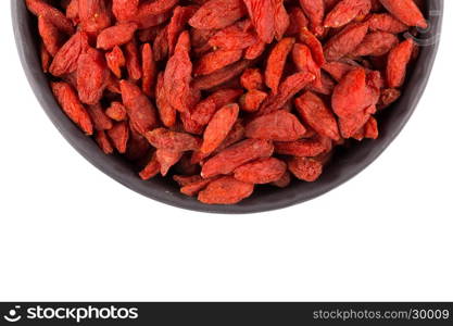 Chinese goji berries in dark stone bowl close up on white background