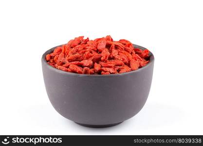 Chinese goji berries in dark stone bowl close up on white background