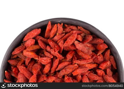 Chinese goji berries in dark stone bowl close up on white background