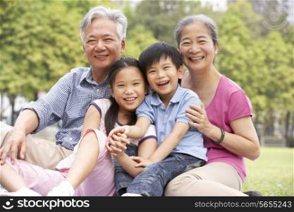 Chinese Grandparents Sitting With Grandchildren In Park