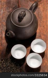 chinese green tea traditional pot and cups over old wood board