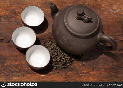 chinese green tea traditional pot and cups over old wood board