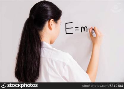 Chinese high school girl in uniform writing on whiteboard
