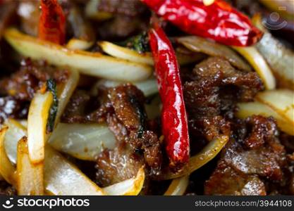 Chinese hot red Chile peppers with beef and vegetables. Filled frame format with selective focus on front pepper.