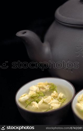 chinese jasmine tea pot and cups over black