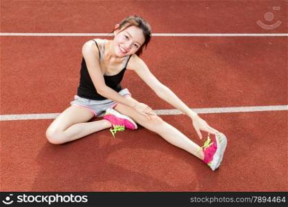 Chinese jogger stretching legs on jogging track