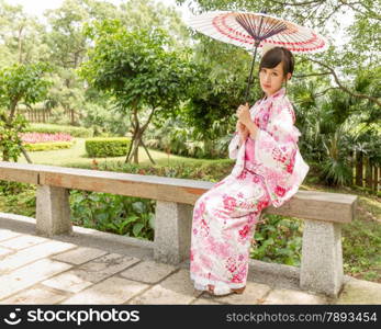 Chinese lady wearing kimono in traditional Japanese style garden