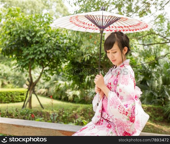 Chinese lady wearing kimono in traditional Japanese style garden