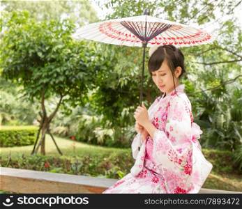 Chinese lady wearing kimono in traditional Japanese style garden