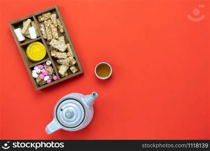 Chinese language mean rich or wealthy and happy.Table top view Lunar New Year & Chinese New Year vacation concept background.Flat lay dessert in wood basket & cup of tea on red backdrop and copy space