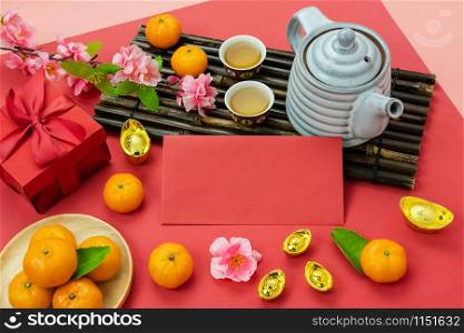 Chinese language mean rich or wealthy and happy.Accessories on Lunar New Year & Chinese New Year vacation concept background.Red pocket money and pink flower with orange on modern red wallpaper.