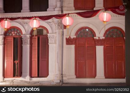 Chinese lanterns in front of a building lit up at night, Chinatown, Singapore