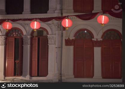 Chinese lanterns in front of a building lit up at night, Chinatown, Singapore