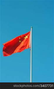 Chinese national five-star red flag fluttering in the wind against blue sky