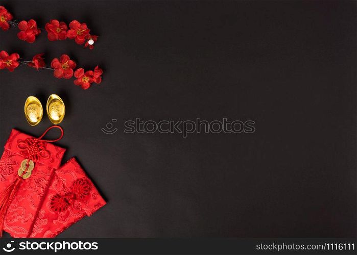 "Chinese new year concept, flat lay top view, Happy Chinese new year with Red envelope and gold ingot (Character "FU" means fortune, blessing, wealth) on black background with copy space for your text"