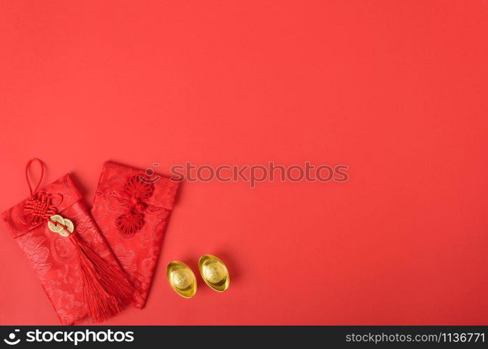 "Chinese new year concept, flat lay top view, Happy Chinese new year with Red envelope and gold ingot (Character "FU" means fortune, blessing, wealth) on red background with copy space for your text"
