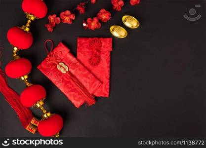 "Chinese new year concept, flat lay top view, Happy Chinese new year with Red envelope and gold ingot (Character "FU" means fortune, blessing, wealth) on black background with copy space for your text"