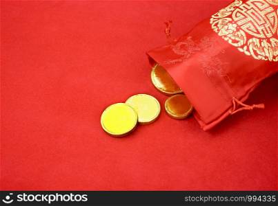 Chinese new year decoration: red fabric packet or ang pow with chinese style pattern and golden coin on red felt fabric