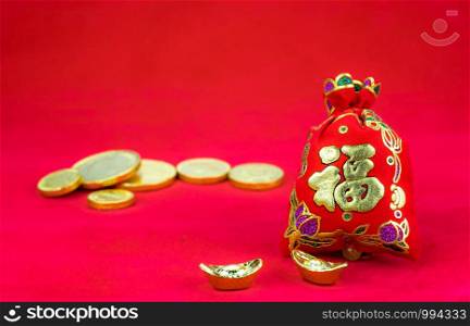 "Chinese new year decoration: red felt fabric packet or ang pow with word "prosperous" and golden ingots on red fabric."