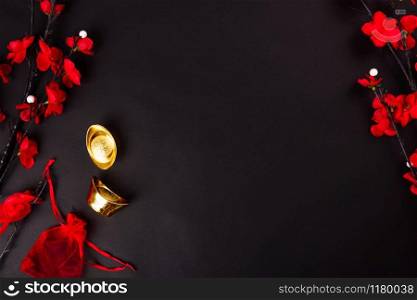 Chinese New Year, flat lay top view, gold bar and Chinese Flower on black background with copy space for your text