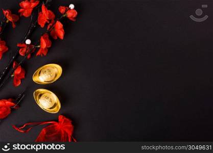 Chinese New Year, flat lay top view, gold bar and Chinese Flower on black background with copy space for your text