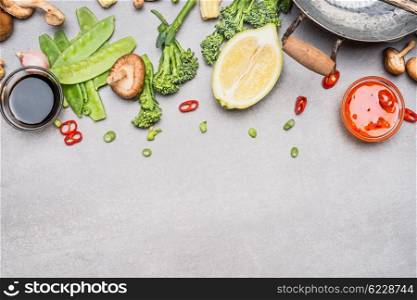 Chinese or Thai cuisine vegetables and spices cooking ingredients on gray stone background, top view, border