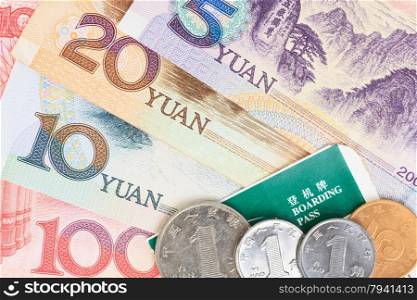 Chinese or Yuan banknotes money and coins from China&rsquo;s currency with boarding pass visa for travel concept, close up view as background