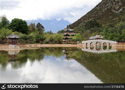 Chinese pagoda and stone bridge in Black dragon park in Lijiang, China