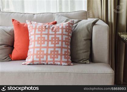 Chinese pattern in orange and deep orange and gray pillows on light gray sofa set