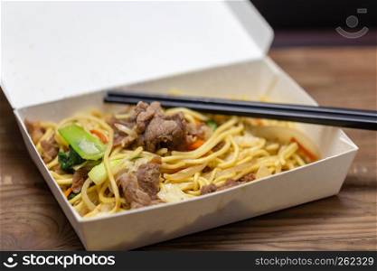 Chinese pork fried rice in lunchbox with chopsticks