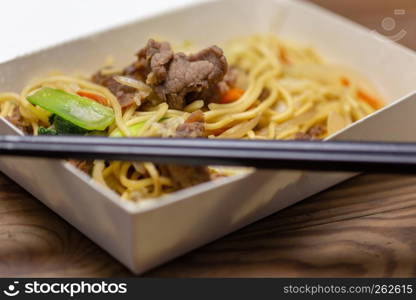 Chinese pork fried rice in lunchbox with chopsticks