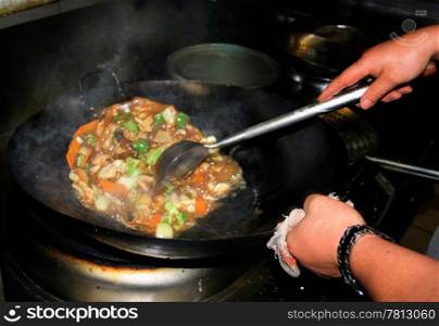 Chinese Restaurant Chicken Dish being Stirred in Wok