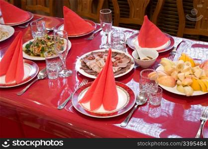 chinese restaurant laid table with bright red glossy tablecloth