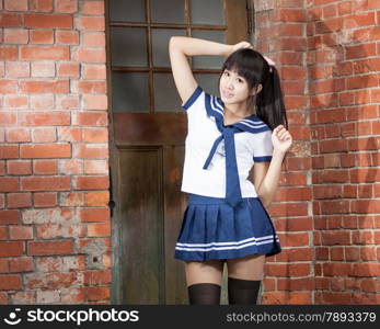 Chinese schoolgirl in front of red brick school building
