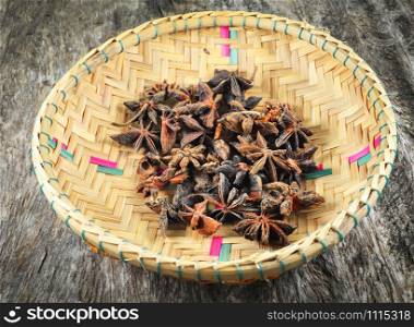 Chinese star anise spice fruit on bamboo basket on old wood background - Other names star aniseed , Badiane , Badian khatai