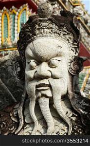 Chinese stone guardian statue close up in Wat Pho Buddhist Temple , Bangkok, Thailand