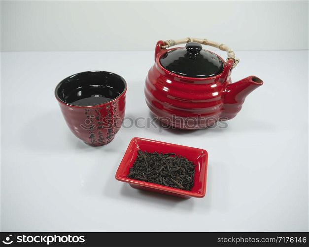 Chinese tea and a red teapot with a cup on the bachground