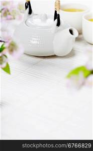 Chinese Tea Set and sakura branch on bamboo mat