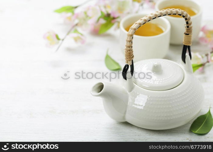 Chinese Tea Set and sakura branch on bamboo mat